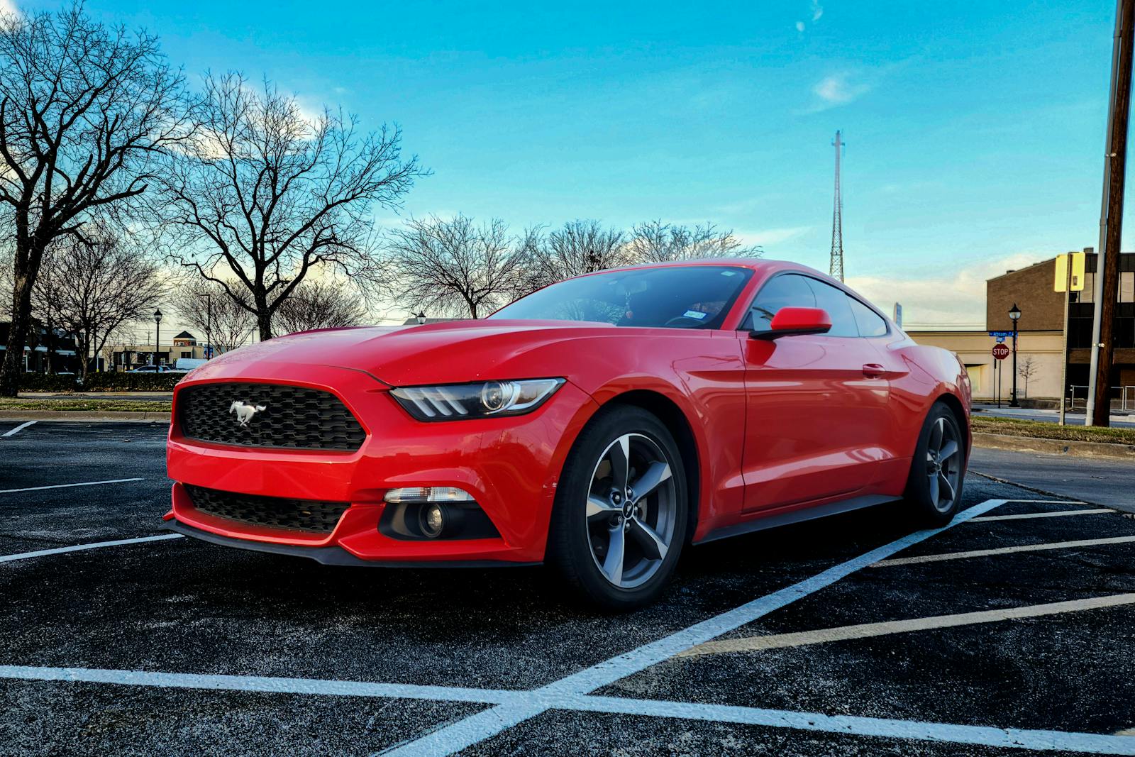 Vibrant red Ford Mustang GT parked on a clear day in Arlington, Texas.